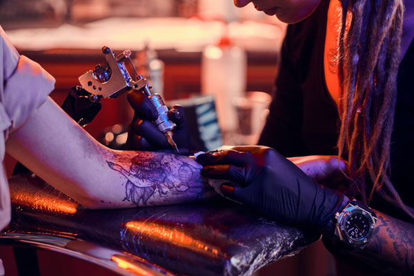 Tatuador haciendo tatuaje realista